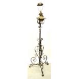 A Victorian brass oil lamp converted to electricity, raised on adjustable cast iron base,