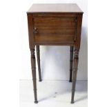 A 19th century mahogany pot cupboard with single cupboard door on ring-turned tapering legs,