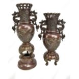 A pair of late 19th/early 20th century Japanese patinated bronze vases with cast twin dragon