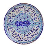 A 19th century Turkish Iznik-style earthenware cobalt glazed charger decorated with floral scrolls