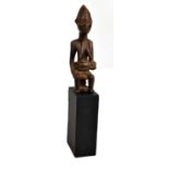 A Baule carved figure of a seated female with child, set to a wooden stand, height of figure only