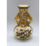 A Japanese Meiji period Satsuma vase with pierced dragon handles, decorated with figures and