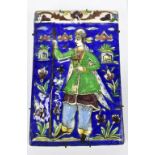 A 19th century Persian Qajar ceramic tile featuring a single figure holding a spear amongst floral