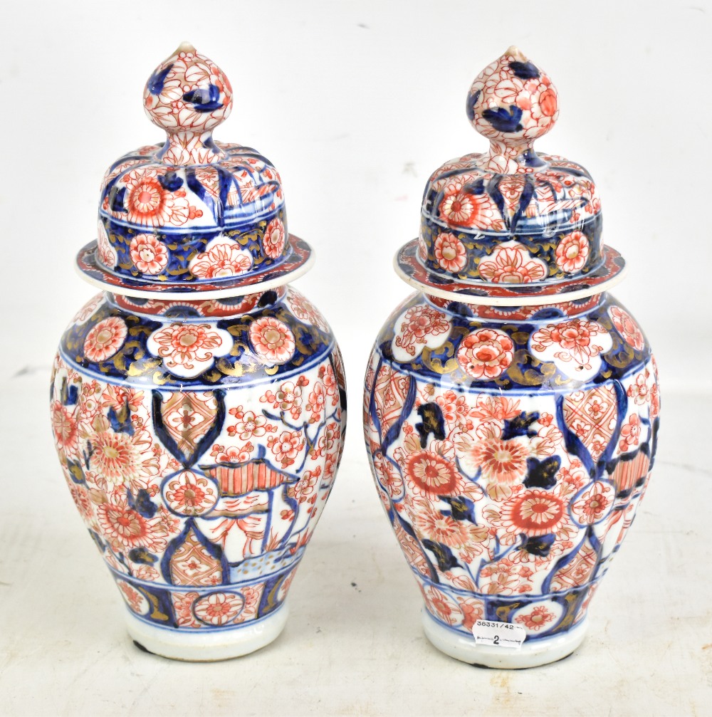 A pair of Japanese Meiji period Imari ribbed lidded vases with underglaze and gilt floral