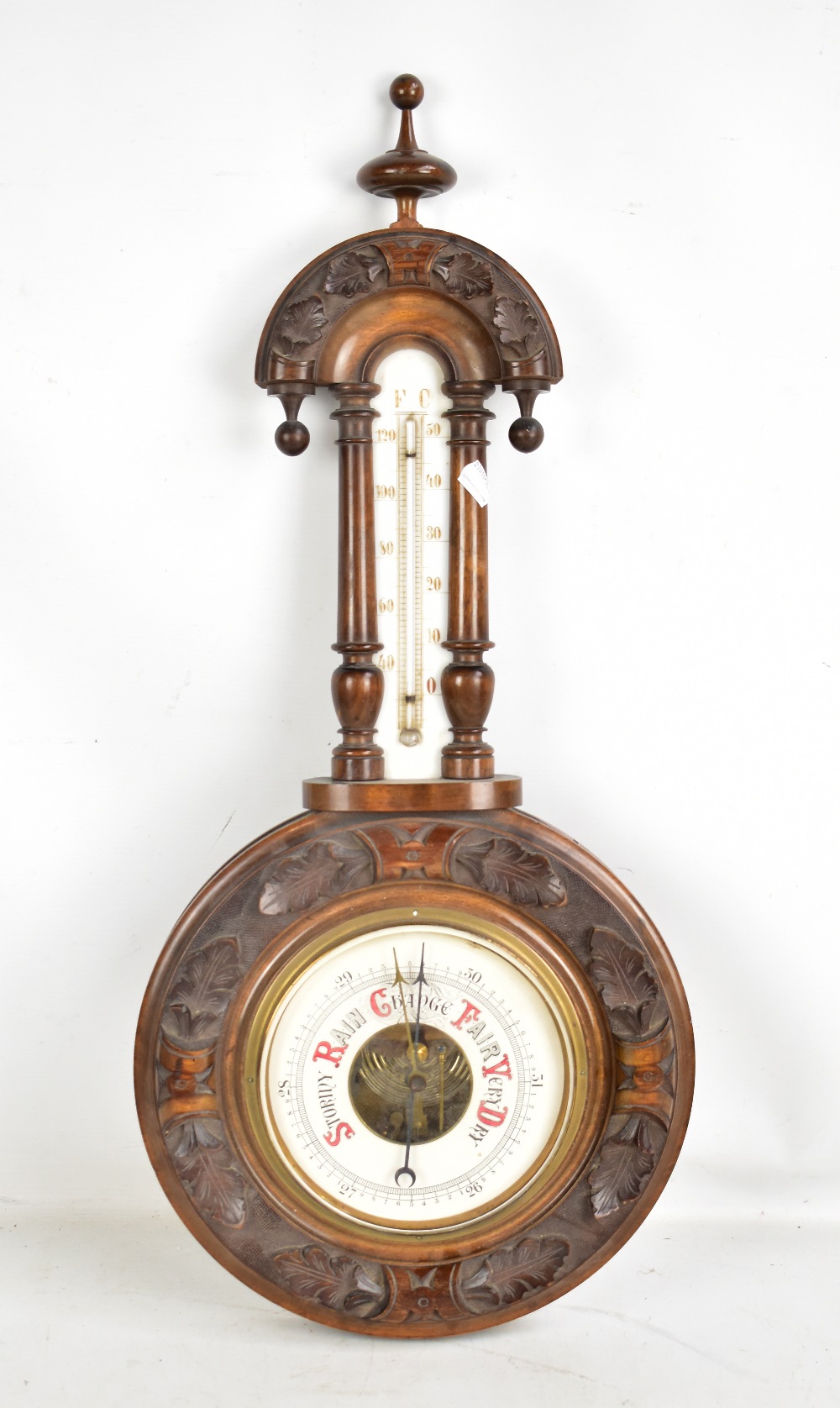 A circa 1900 carved walnut and beech wheel barometer with relief carved detail and upper
