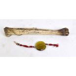 An animal bone drilled with suspension loop, length 27.5cm, and a glass pendant with silk band (