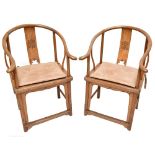 A pair of northern Chinese elm yoke back chairs with caned seats, height 100cm (2).