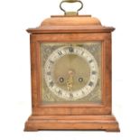 A 20th century walnut cased mantel clock, the brass face with silvered dial with Roman numerals, the