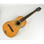 An early 20th century six string acoustic guitar with inlaid and mother of pearl decoration, cased.