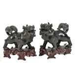 A pair of Chinese carved hardstone Kylin on shaped wooden bases, length 12cm, height 12cm.