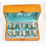 TIEN SHING; a cased set of late 19th century Chinese Export silver napkin rings, all featuring