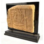 An Egyptian carved sandstone plaque with incised decoration, approx 19 x 22.5cm, now mounted for