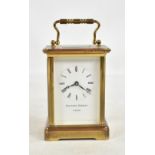 MATTHEW NORMAN; a brass cased carriage clock, the circular enamel dial set with Roman numerals,