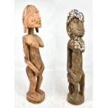 A carved African Yaruba figure, height 68cm, and a further African figure adorned with cowrie