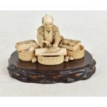 A Japanese Meiji period carved ivory okimono depicting a fishmonger, signed to base, height 7cm,