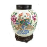 A late 19th century Chinese porcelain ginger jar painted in enamels with two phoenix amongst flowers