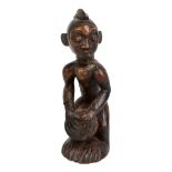 A Congo carved wooden drumming figure, height 25cm.
