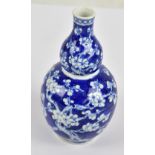 A late 19th/early 20th century Chinese porcelain double gourd vase painted in underglaze blue with