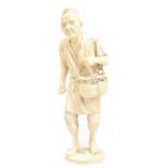 A good Japanese Meiji period carved ivory okimono of a farmer with basket of seed over his shoulder,