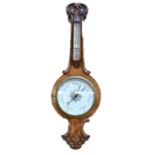 A Victorian walnut banjo barometer with carved detail above white circular dial, height 102cm.