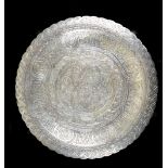 An Eastern white metal circular plate with chased decoration throughout, impressed marks to reverse,