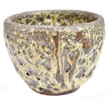 A Japanese earthenware bowl with thick cream and brown eruption glaze, three character mark to base,