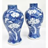 A pair of late 19th/early 20th century Chinese blue and white baluster vases with painted four