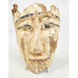 An Egyptian wooden mask with traces of painted decoration, height approx 24cm (af).Additional