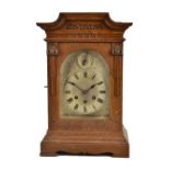 GUSTAV BECKER; an early 20th century oak cased bracket clock with carved decoration surrounding a