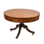 A 19th century mahogany drum table with four true and four faux drawers on turned column to sabre
