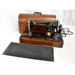 SINGER; a sewing machine in oak domed case and with Singer rubber mat (2).