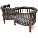A Victorian mahogany framed conversation seat with spindle back and blue floral upholstery, on