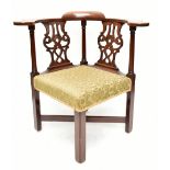 A George III Chippendale-style mahogany framed corner chair with carved splats and floral