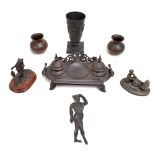 A group of decorative metalware including an ink standish, vase, figure of a seated gentleman