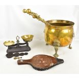 A large Dutch style brass coal or log bin raised on paw feet, a set of scales, bellows, fire