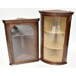 A reproduction mahogany veneered bowfronted hanging corner cabinet with gilt floral swag mounts