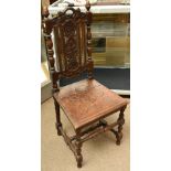 A Victorian oak hall chair with carved foliate detail to back and seat on turned and block