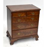 A reproduction mahogany chest of small proportions with two short over three long drawers, raised on
