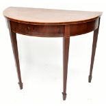 An Edwardian mahogany and inlaid demilune side table on tapered square section supports to peg feet,