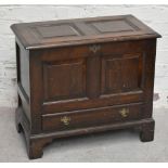 A reproduction oak coffer of small proportions, the hinged lid enclosing storage compartment above