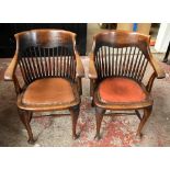 A pair early 20th century oak spindle back arm chairs with studded leatherette upholstered seats