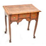A late 18th century walnut lowboy with burr top above three drawers, carved detail and pendants,
