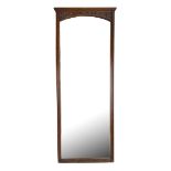 A late 19th/early 20th century rectangular mahogany wall mirror with foliate carved frieze and