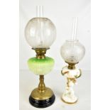 Two late 19th century oil lamps, the first with cherubic figural column and applied foliate detail