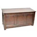A late 18th century carved oak coffer, the front with panelled decoration, raised on block supports,