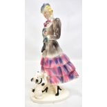 A Continental Art Deco figurine depicting a lady walking beside an excited dog impressed No.37348 to