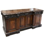 A Victorian oak inverted break front sideboard with carved detail throughout, the frieze featuring