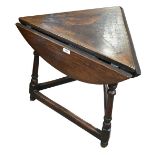 A 19th century oak drop leaf cricket table raised on bun feet, height 60cm, diameter 59cm.Additional