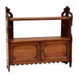 A 19th century mahogany wall hanging set of shelves with twin doors to lower section, with carved