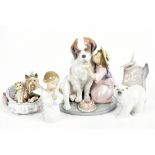 LLADRO; a collection of four figurines including a girl beside a St Bernard dog and birthday cake,